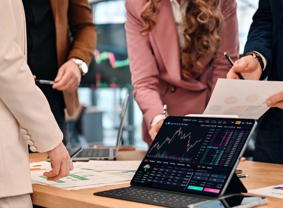 Business meeting in an office, workers discussing business affairs using gadgets and papers with charts